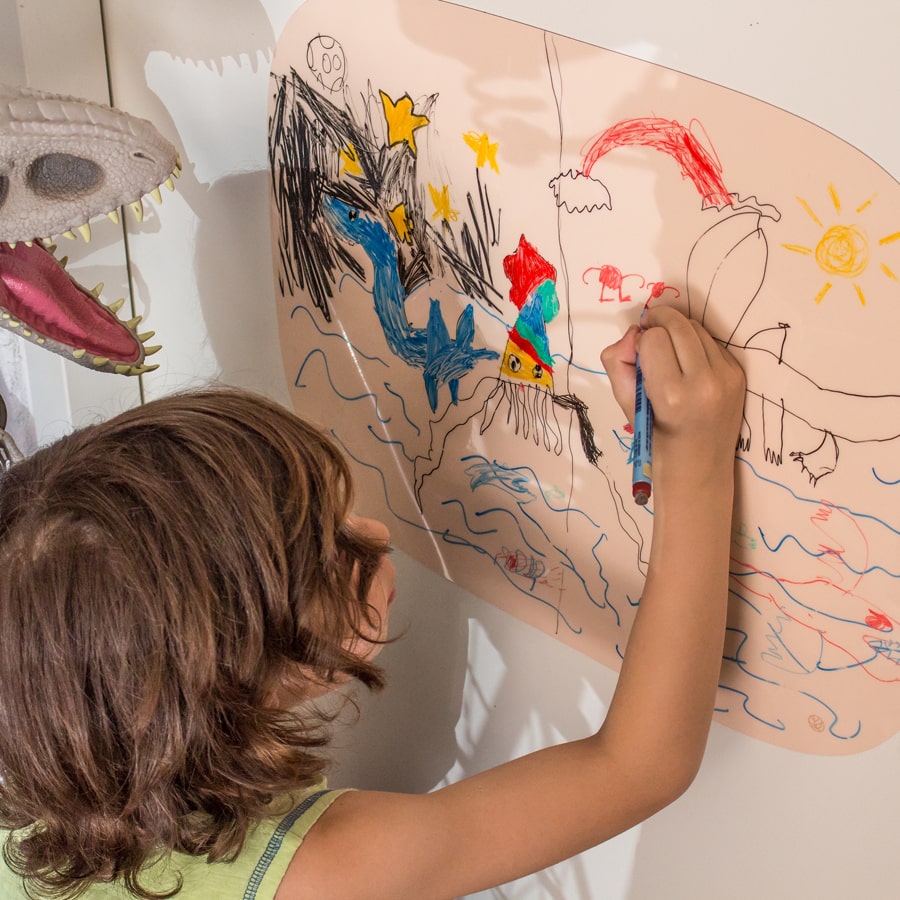 Jongen tekent op organische Sticky blanco board extra groot Whiteboard van Greenstory geplakt op een kastdeur